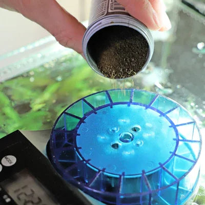 Distribution de nourriture pour poissons dans un aquarium avec distributeur automatique bleu