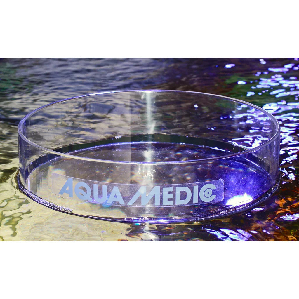 Anneau d’alimentation transparent Aqua Medic flottant sur eau d’aquarium récifal